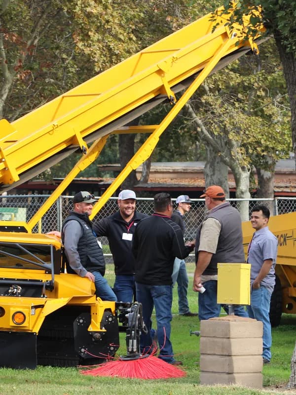 Growers around a harvester in the equipment yard