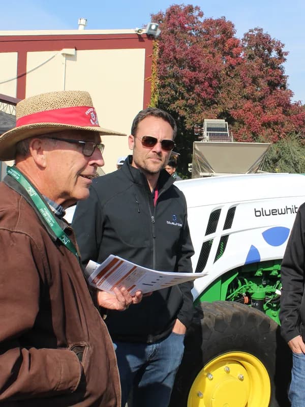 A grower talking through a machine with the people who build it